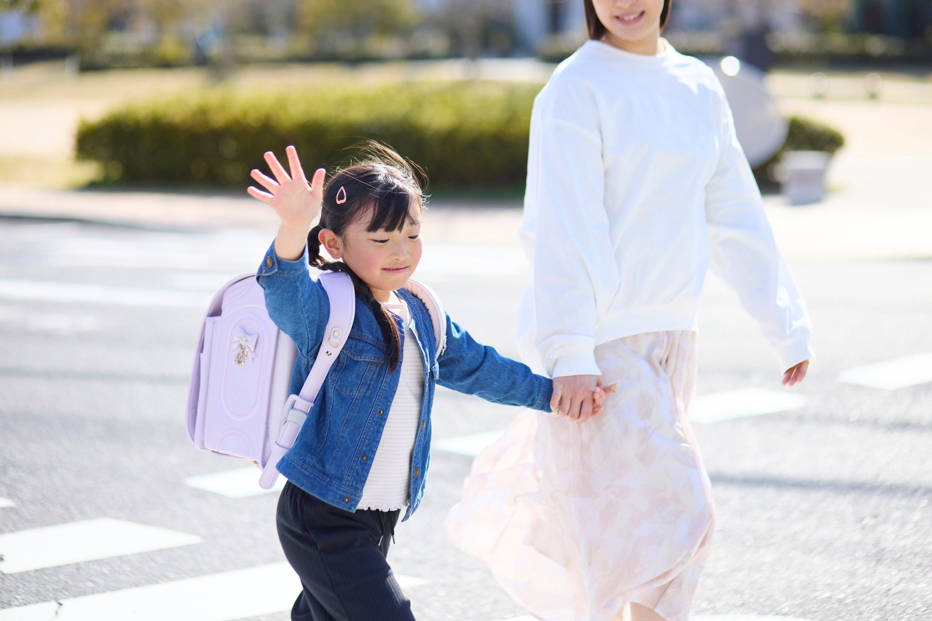 Elementary School Girl Walking with Her Mother Across a Crosswalk